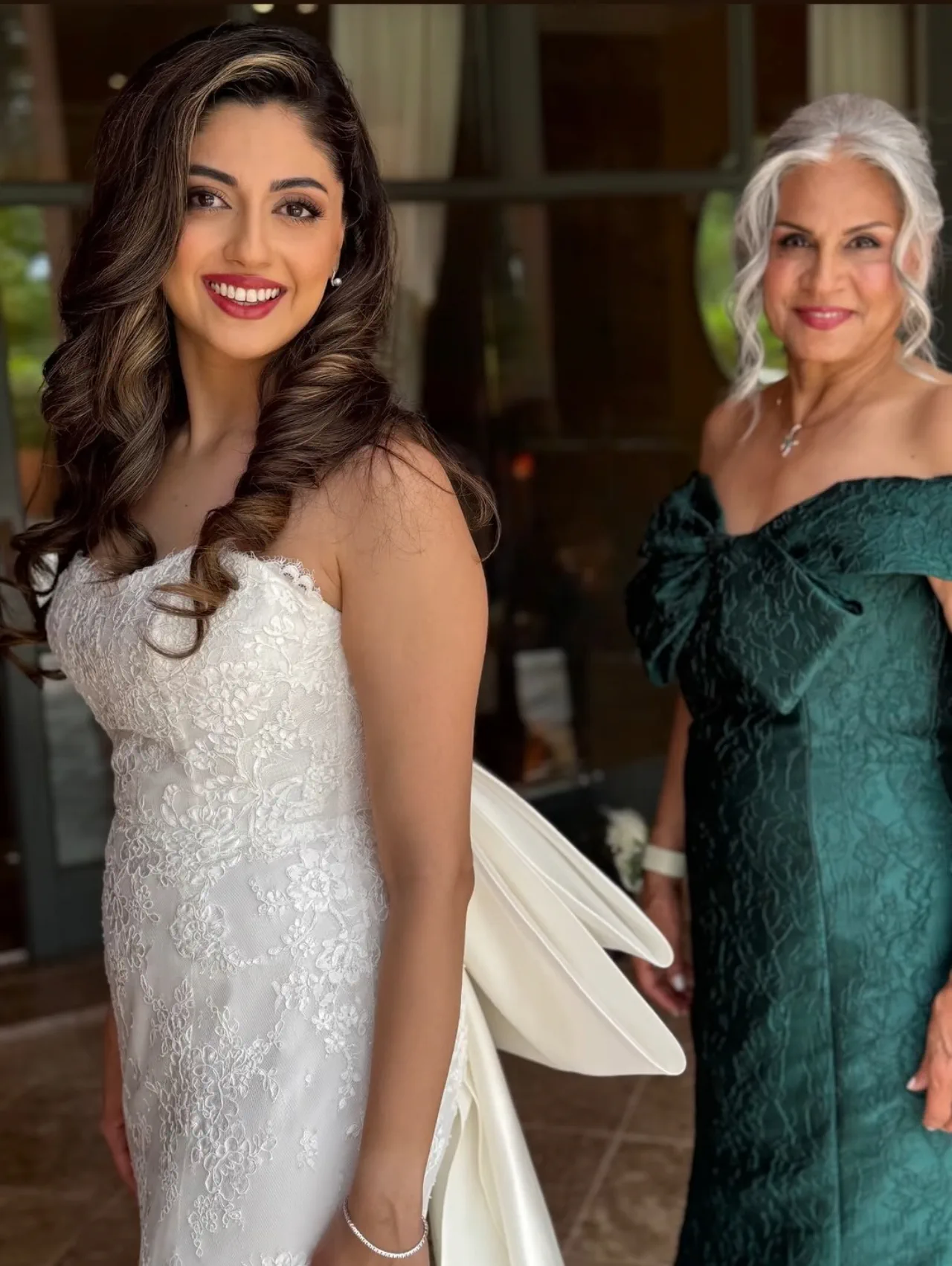 Shirin, con ondas largas y vestido de encaje, junto a su madre