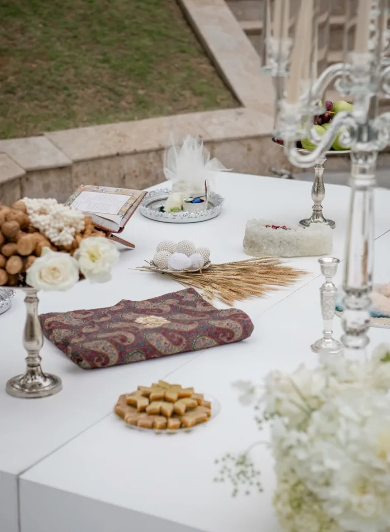 El sofreh aghd, la mesa de la ceremonia persa, con candelabros de plata, dulces y flores blancas