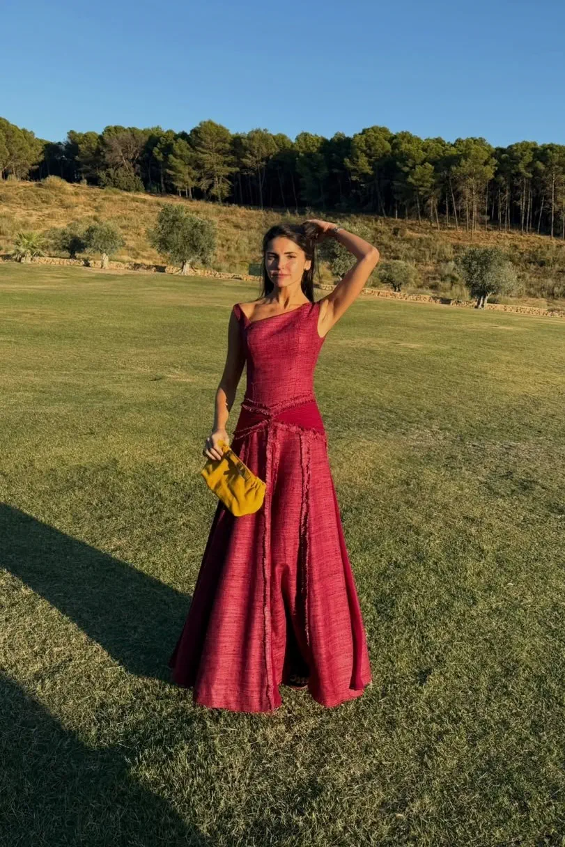 María en la hora dorada, con la falda larga del vestido y el pinar de Cortijo Curiel al fondo