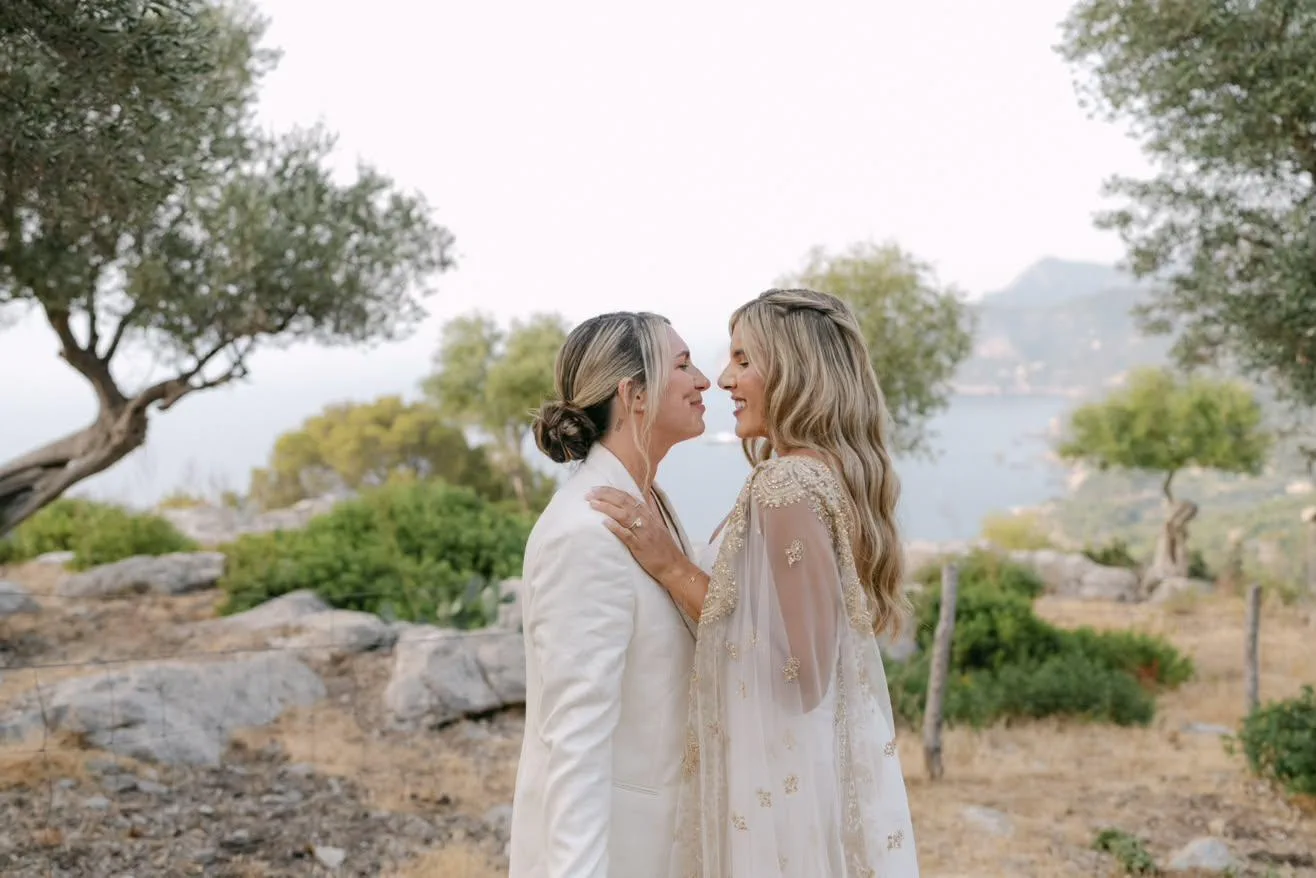 Las dos novias, frente a frente, con el mar y la sierra de Tramuntana detrás, en Mallorca