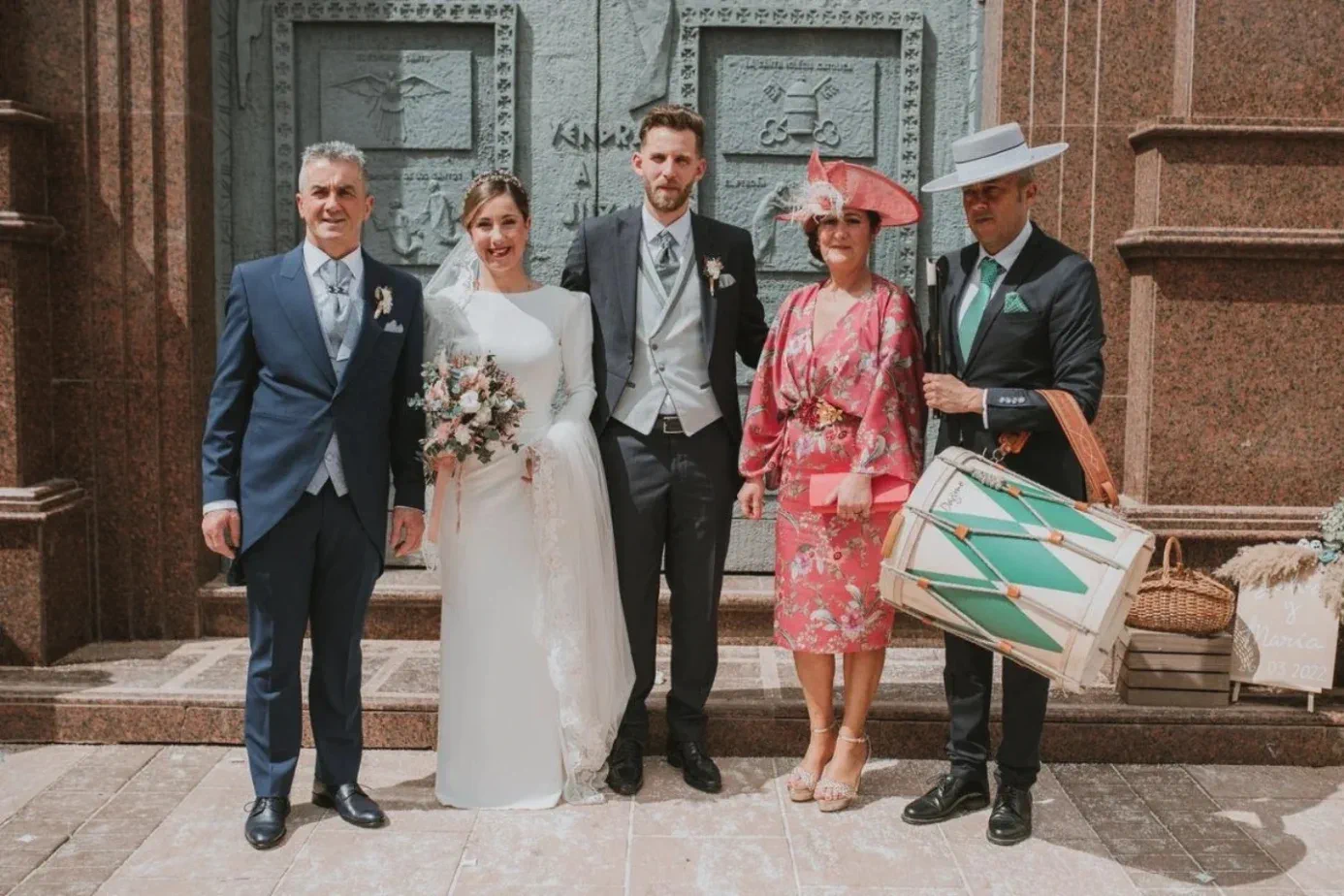 Los novios con su familia y un tamborilero en la puerta de la iglesia del Rosario