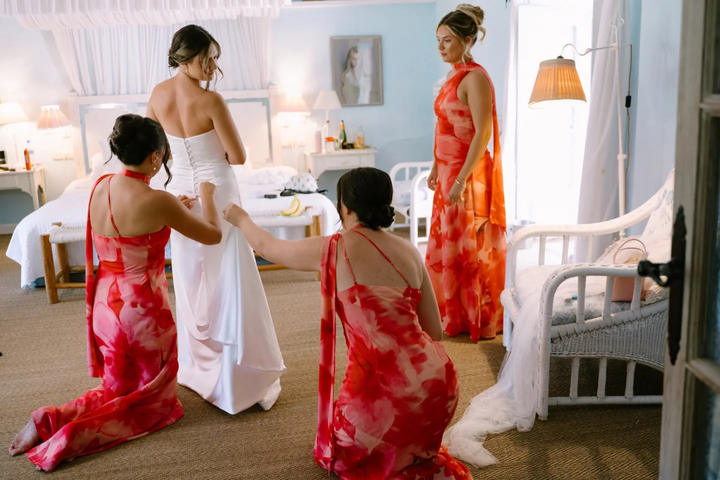 Las damas de honor ayudan a la novia con el vestido en el dormitorio de El Molino del Duque, Manilva