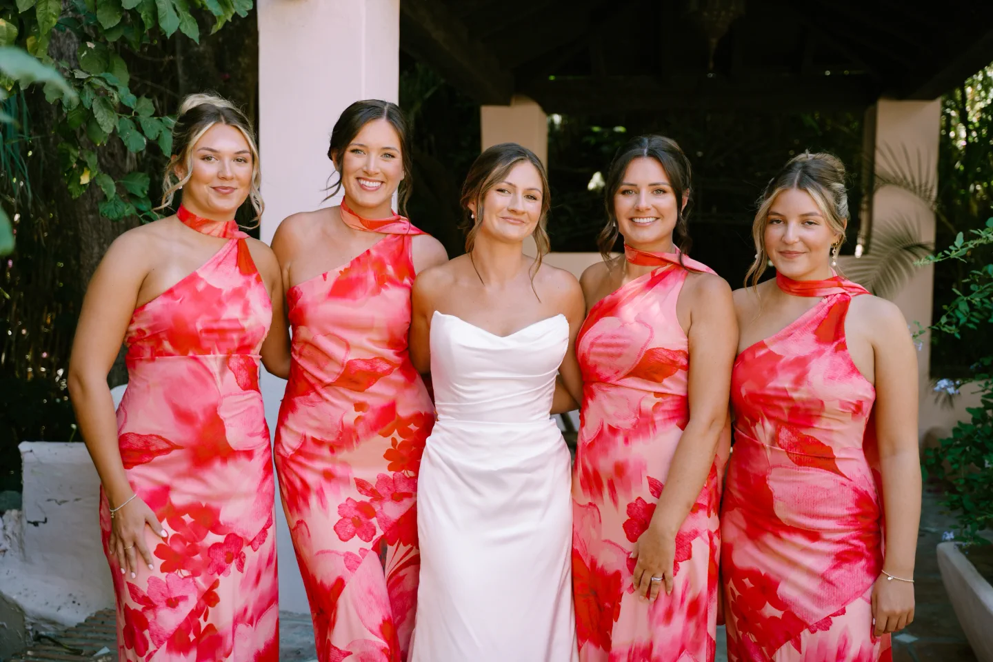 La novia con sus damas de honor, de vestidos rosas, en el jardín de El Molino del Duque