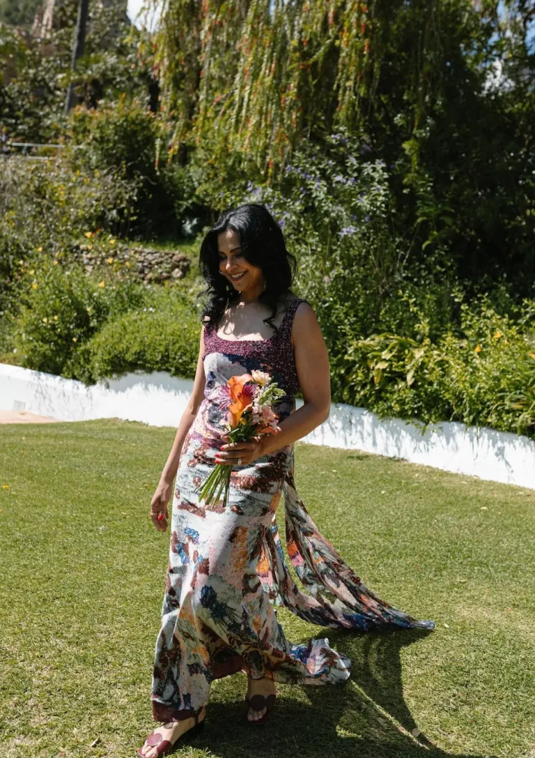 La madre de Hanadi, con ondas y un ramo de flores, camina por el césped