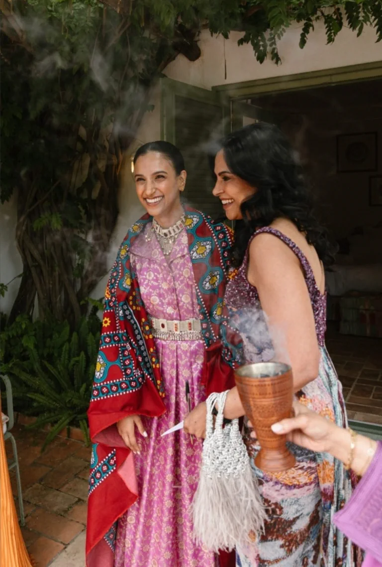 Dos mujeres de la familia, con ondas y vestidos de colores, durante el ritual del incienso