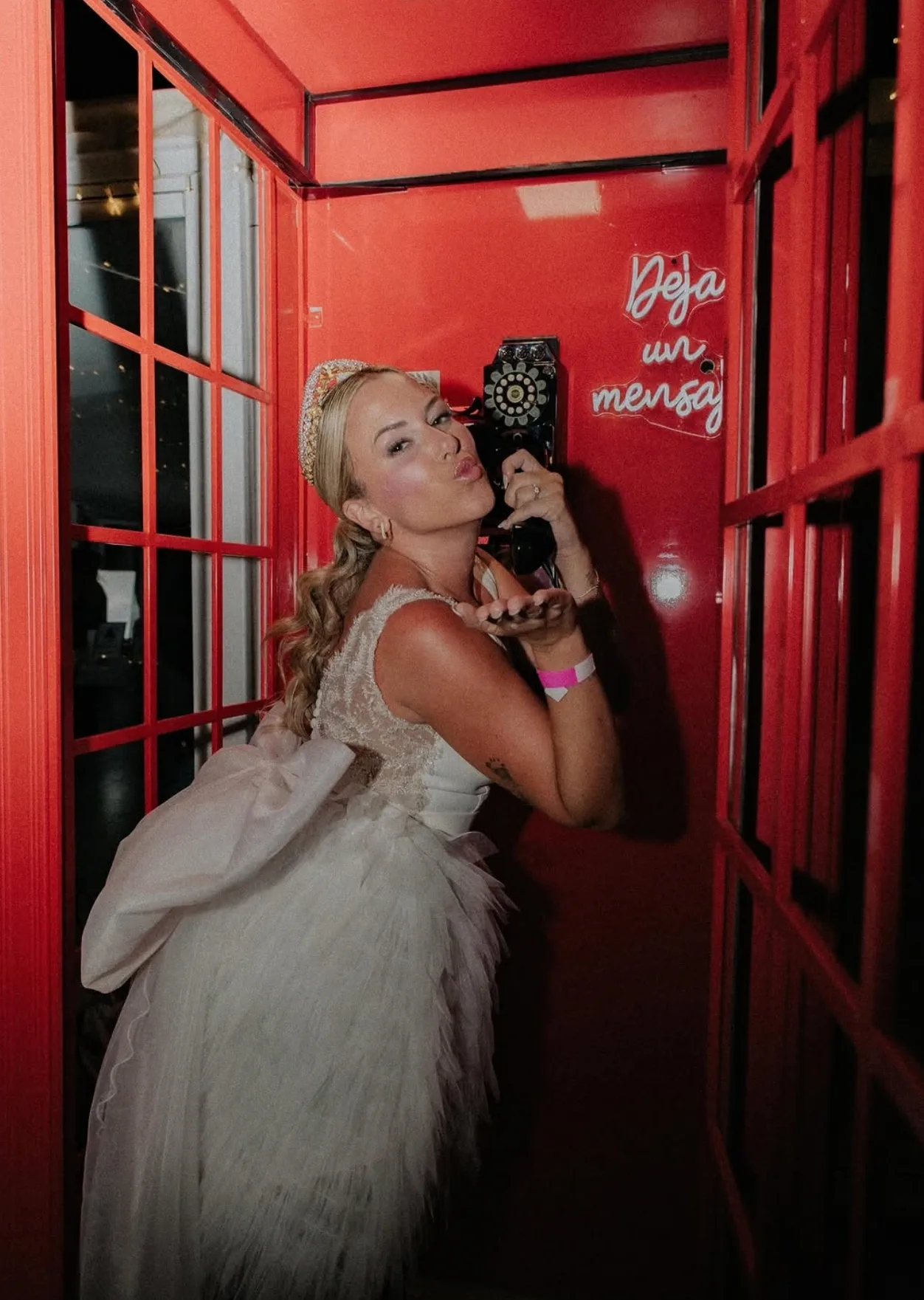 La novia posa con el auricular en una cabina de teléfono roja durante la fiesta de su boda en Finca Bellavista