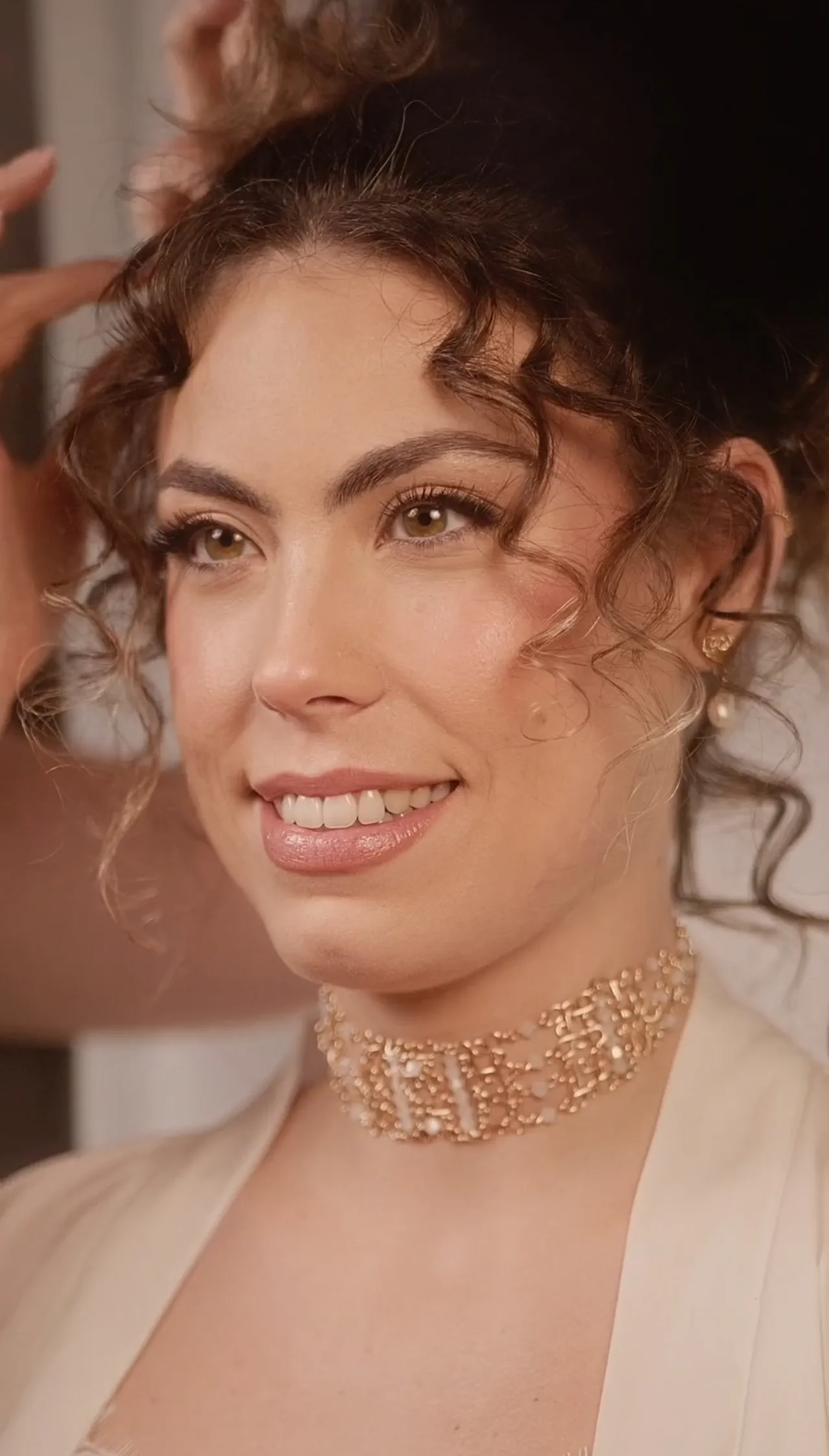 La modelo sonríe con el recogido de rizos terminado y el choker de Argia Tocados