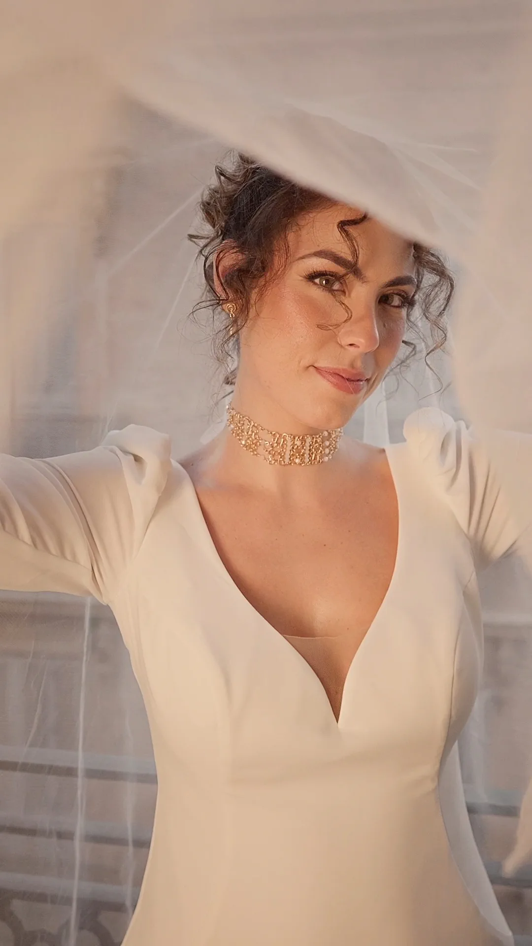 La modelo con velo, recogido de rizos y vestido de escote en pico